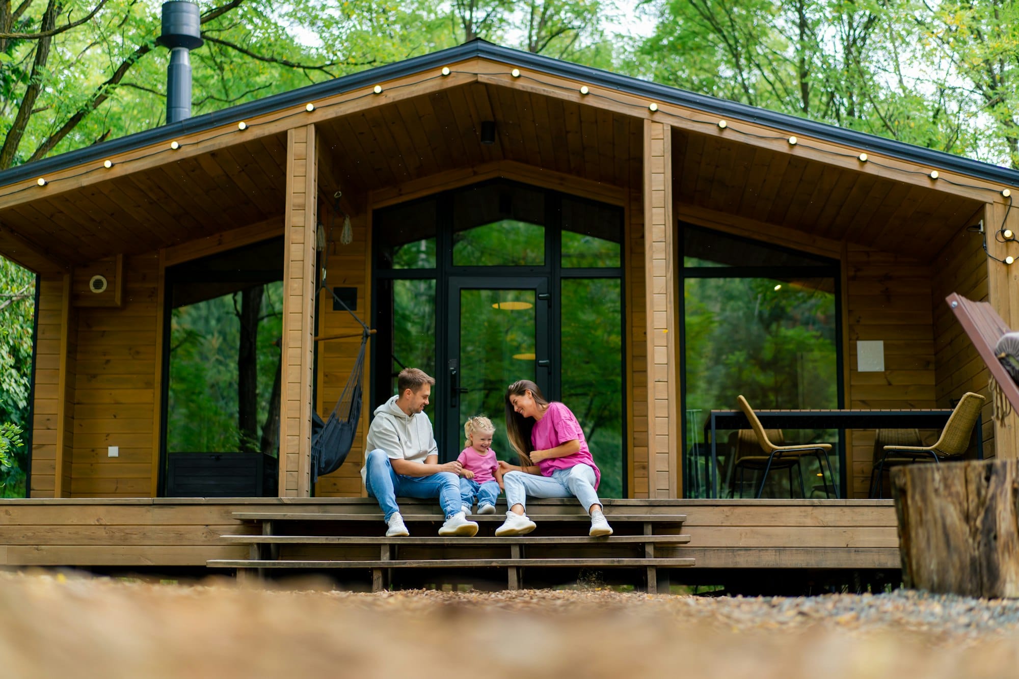 Young family mum dad and daughter happily spending time together in their country house in the woods